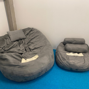 Bean Bags: This photo has two bean bags, one large lounger, and the second is a smaller bean bag. These are used in sensory spaces. 